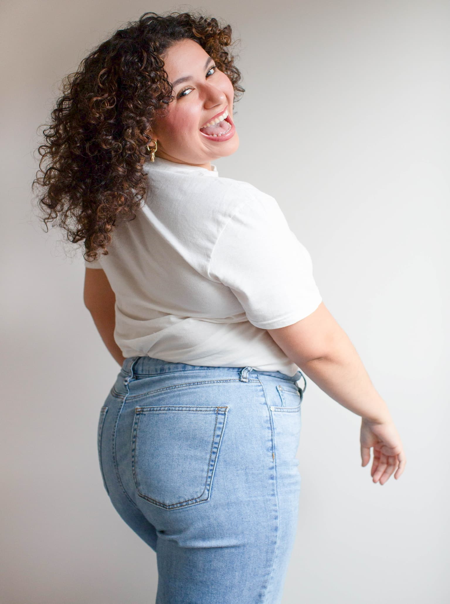 Roselyn Hernandez standing with her back to the camera, looking over her shoulder and laughing