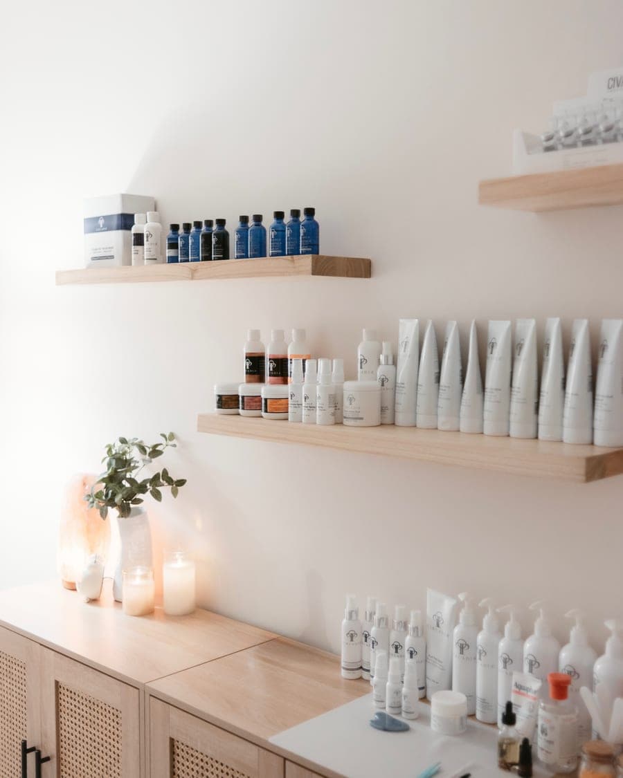 Shelves of professional skincare above a candlelit worktop in the Nourish Skin Nashville studio