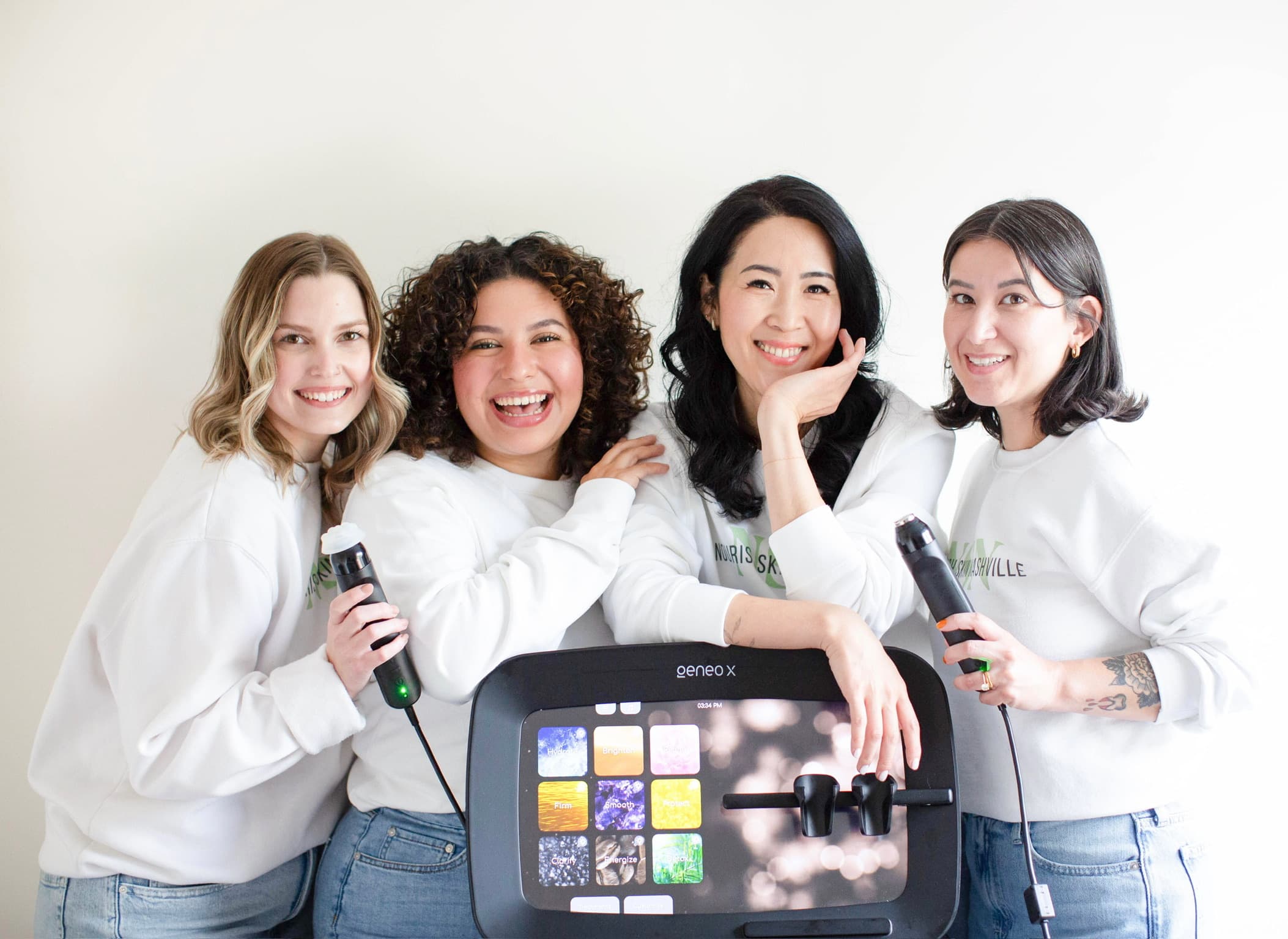 The four Nourish Skin Nashville estheticians around the studio's Geneo X device, two of them holding its handpieces